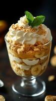 Delightful dessert featuring layers of whipped cream, bananas, and crushed cookies in a clear glass cup photo