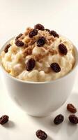 Creamy rice pudding topped with brown sugar and raisins served in white bowl on light background photo