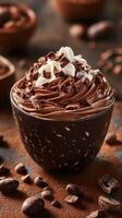 Delicious chocolate mousse served in a dark bowl with whipped cream and chocolate shavings on top photo