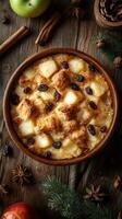 Warm apple bread pudding with spices and raisins served in rustic bowl on wooden table during autumn photo