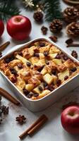 Warm apple bread pudding with raisins and spices on a festive table setting photo