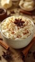 Creamy rice pudding topped with star anise and cinnamon served in a rustic bowl on a wooden table photo
