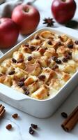 Warm apple bread pudding topped with cinnamon and raisins ready for dessert at a cozy kitchen table photo