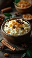 Creamy rice pudding topped with raisins and spices served in a rustic wooden bowl on a dark wooden table photo
