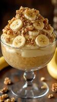 Delicious banana pudding dessert served in a glass bowl with crushed nuts and fresh banana slices on top photo