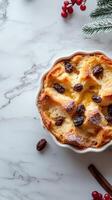 Delicious bread pudding topped with raisins served on a marble countertop during the holiday season photo