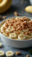 Creamy banana pudding topped with crunchy crumble served in a bowl with fresh bananas photo