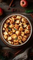 Baked bread pudding with apples and raisins on a rustic wooden table surrounded by cinnamon and apples photo