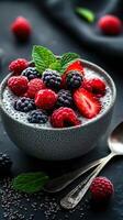 Fresh berry chia seed pudding served in a textured bowl with mint garnish on a dark background photo