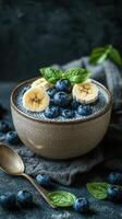 Delicious bowl of chia seed pudding topped with fresh bananas and blueberries in an elegant setting photo