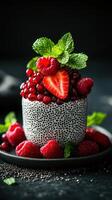 Fresh berry dessert topped with mint leaves presented on a dark background photo