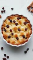 Delicious homemade bread pudding with raisins and almonds served in a white baking dish photo