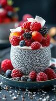 Fresh berry dessert topped with coconut flakes in a textured bowl on a dark background photo