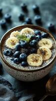 Chia pudding topped with banana slices and blueberries served in a decorative bowl photo