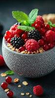 Fresh mixed berries with granola and mint served in a textured bowl for a healthy snack photo
