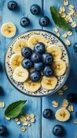 Delicious chia seed pudding topped with fresh blueberries and bananas on a rustic blue wooden table photo