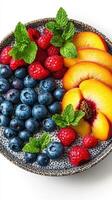 Fresh fruit bowl with peaches, blueberries, and raspberries on a white background in a modern presentation photo