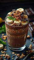 Delicious chocolate banana parfait with granola and mint garnish served in a clear glass cup photo