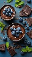 Mouthwatering chocolate mousse topped with fresh blueberries and mint on rustic wooden background photo