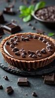 Decadent chocolate tart with dark chocolate chips on a dark stone surface in a beautifully arranged kitchen setting photo
