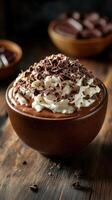 Delicious chocolate mousse topped with whipped cream and chocolate shavings served in a rustic bowl photo