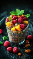 Chia seed dessert topped with fresh raspberries and almonds served in a clear glass photo