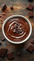 Rich chocolate sauce prepared with semi-sweet chocolate and chocolate chips on a rustic wooden table photo