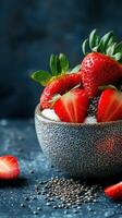 Fresh strawberries with yogurt and chia seeds in a textured bowl set against a dark backdrop photo