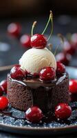 Delicious chocolate dessert topped with vanilla ice cream and cherries on a dark plate photo