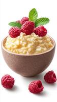 Creamy rice pudding topped with fresh raspberries and mint in a rustic bowl photo