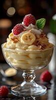 Delicious dessert featuring bananas, raspberries, and creamy topping served in an elegant glass bowl photo