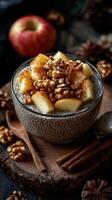 Chia pudding topped with fresh apples, walnuts, and cinnamon served on a rustic wooden background photo