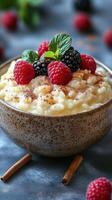 Creamy rice pudding topped with fresh berries and mint leaves in a rustic bowl on a dark surface photo