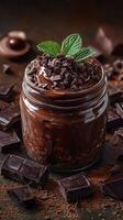Decadent chocolate dessert topped with mint leaves and chocolate shavings in a glass jar photo