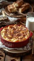 Delicious baked banana pudding with a rich topping served with a glass of milk in a cozy kitchen setting photo