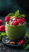 Delicious green smoothie with raspberries and mint on a dark marble surface photo