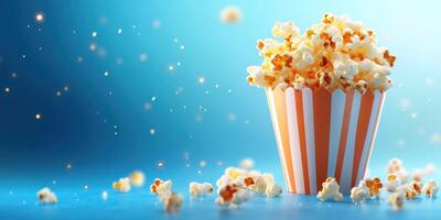 Freshly popped popcorn in a striped container with sparkling backdrop at a movie theater setting photo