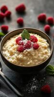 Creamy rice pudding topped with fresh raspberries and mint in a stylish bowl photo