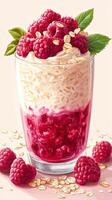 Dessert parfait with layers of raspberry, cream, and oats served in a clear glass cup photo