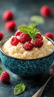 Delicious creamy rice pudding with fresh raspberries and mint leaves in an ornate bowl photo