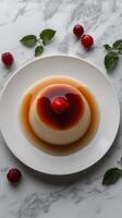 Delicious dessert featuring creamy flan topped with a fresh raspberry and caramel sauce on a marble table photo