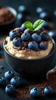 Delicious dessert with blueberries and chocolate served in a black bowl on a textured dark background photo