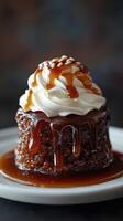 Moist caramel pudding with whipped cream topping served on a white plate photo