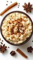Delicious creamy rice pudding topped with spices and garnished with star anise served in a bowl on a white surface photo