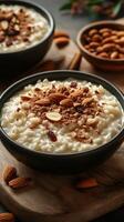 Delicious rice pudding with almonds served in black bowls on a wooden table photo