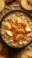 Warm oatmeal topped with fresh apple slices and a sprinkle of cinnamon served on a cozy morning photo