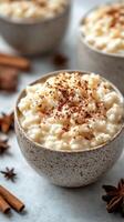 Creamy rice pudding topped with cinnamon sits in rustic bowls surrounded by fragrant spices photo