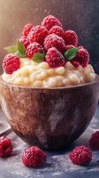 Creamy dessert topped with fresh raspberries in a rustic wooden bowl on a dark background photo