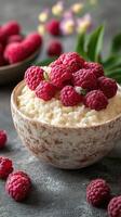 Fresh raspberries atop creamy rice pudding in an elegant bowl on a rustic table photo