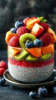 Colorful fruit and chia seed parfait layered in a clear glass dish with vibrant toppings photo